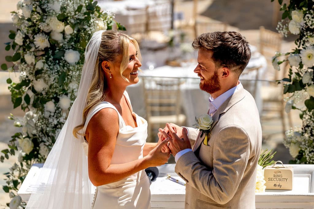 Bride and groom exchanging rings during outdoor wedding ceremony in Marbella Spain