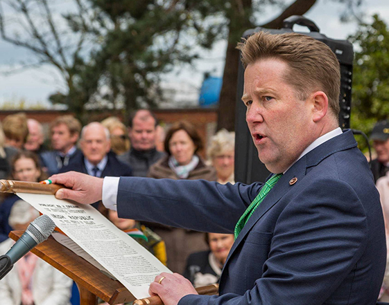 Minister Darragh O'Brien reading the proclamation outside St. Sylvester's Church in Malahide, commemorating the 1916 Easter Rising. Photo by Dougie Farrelly, Professional Photographer | Silverscreen Film & Photography.
