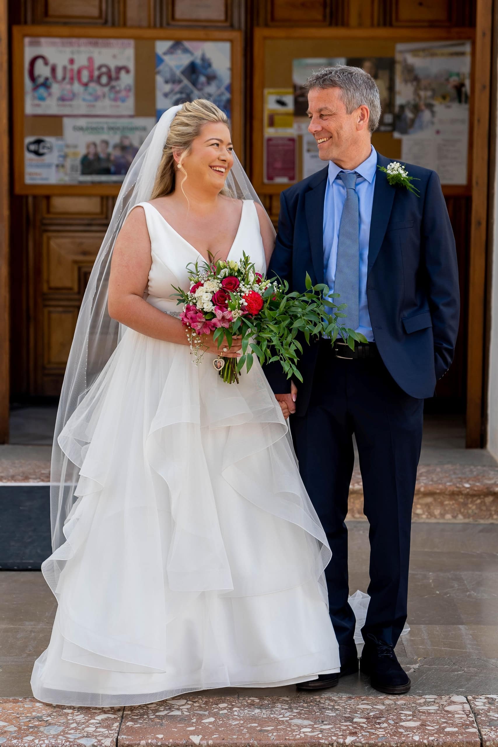 Bride and father smiling at each other outside El Salvador church in Nerja Spain, photographed by Dougie Farrelly of silverscreen.ie
