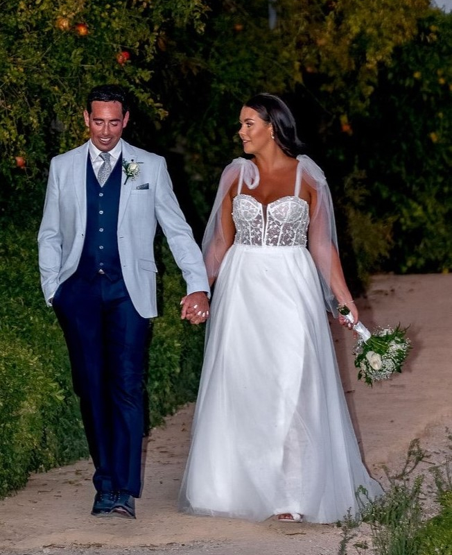 Irish bride and groom walking together at Costa del Sol wedding in Spain holding hands along garden path