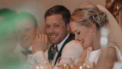 A quiet, candid moment during a wedding reception at Cabra Castle, Ireland. Bride smiling during her Cabra Castle wedding reception in Ireland, photographed by Dougie Farrelly / Silverscreen Photography & Video