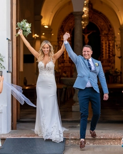 Ruth and James celebrate as they leave the church following their wedding ceremony in Spain. Photo: Dougie Farrelly / Silverscreen Productions (Photography & Video). Newlyweds Ruth and James celebrating together at the church entrance following their wedding ceremony in Spain.