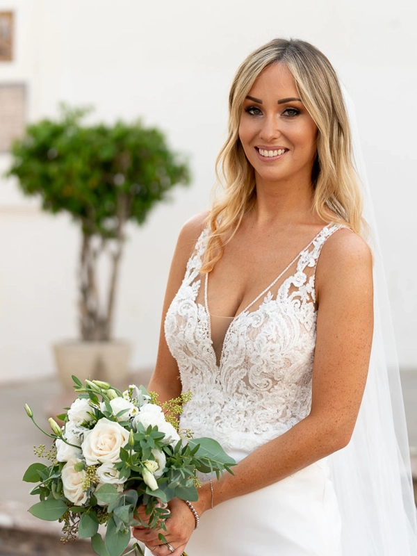 Bride Ruth holding a bouquet of white roses for her wedding portrait during her celebrations in Nerja, Spain.